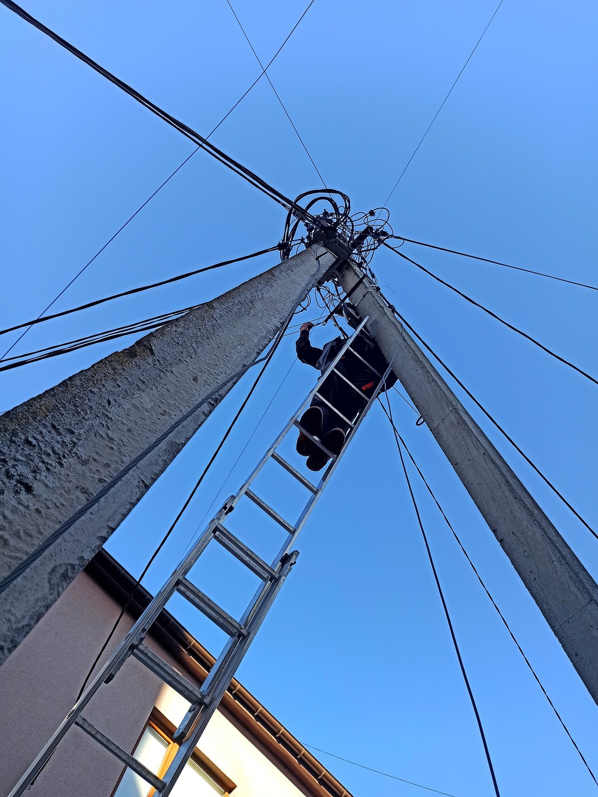 Técnico instalando infraestructura de fibra óptica en un poste.
